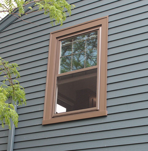 brown window and window trim with blue siding