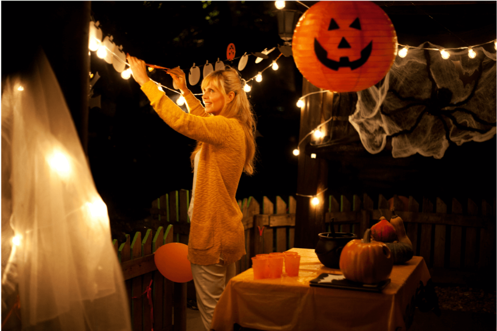Woman putting up Halloween decorations at home