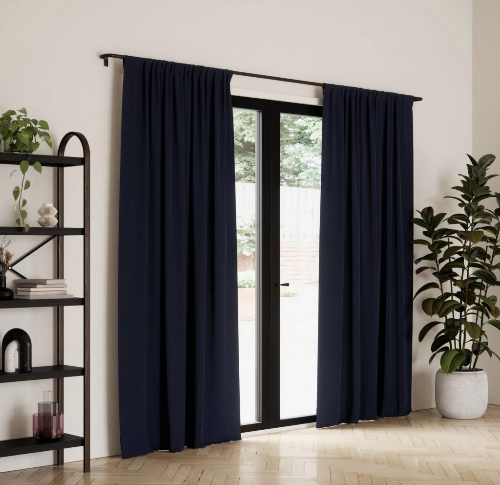 Blackout curtains covering a sliding glass door that leads out to a patio. 